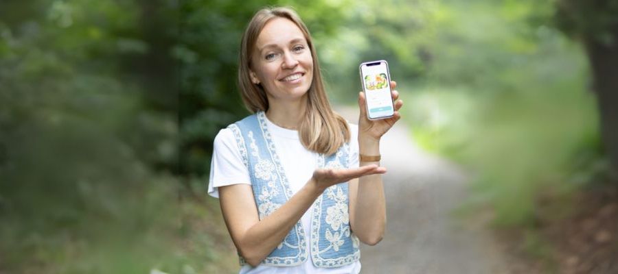 &copy; KiddyTrip | The founder demonstrates her app on her mobile phone