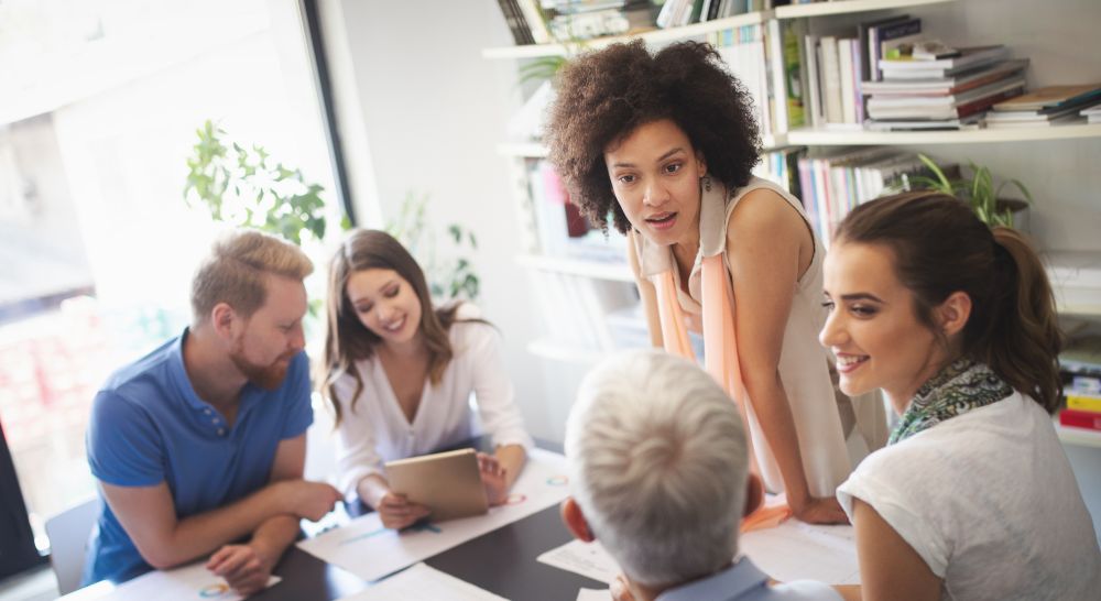 A group of people are sitting together at a table, chatting amiably.