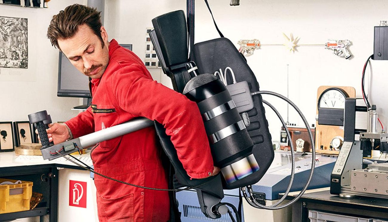 A man in a red jacket is trying out a jetpack.