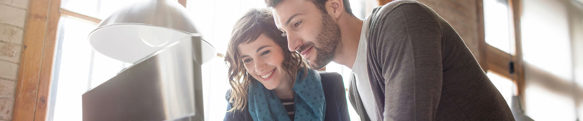 Une jeune femme et un jeune homme regardent un écran.