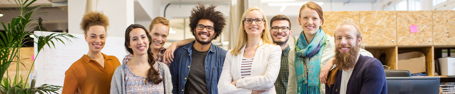 Jeunes hommes et jeunes femmes se tiennent en rang l&#039;un à côté de l&#039;autre et sourient ou rient.