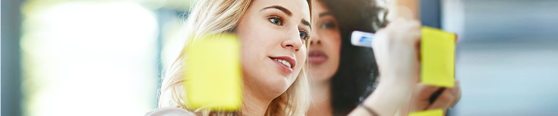 Two young women label post-its.