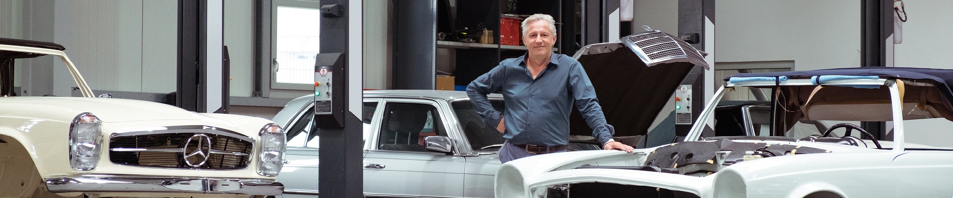 Andreas Meyer steht in der Werkstatt neben einem Auto