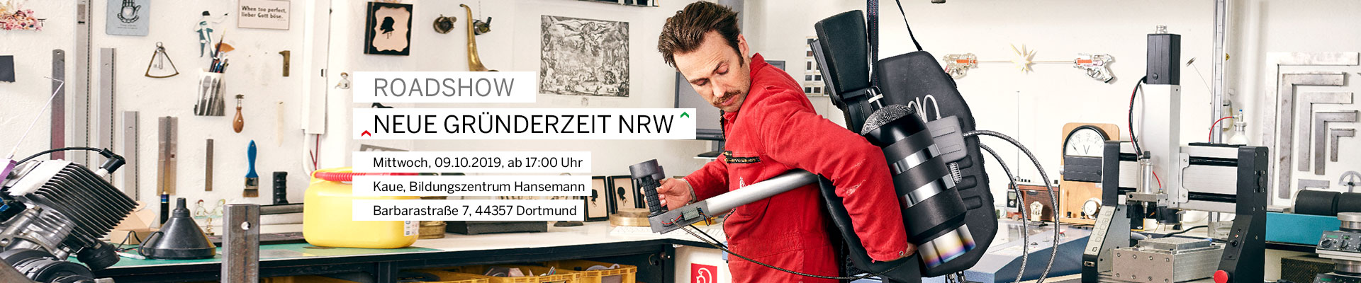 Ein Mann in einem roten Mechaniker-Anzug hat sich einen Raketenantrieb auf den Rücken geschnallt.