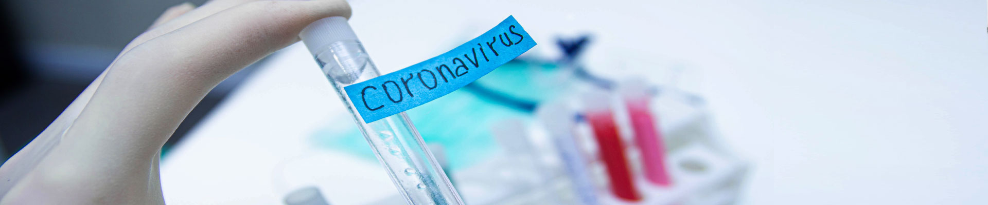 Hand hält Reagenzglas mit Aufschrift Coronavirus.