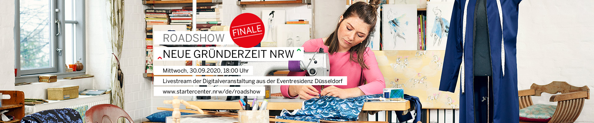 Eine junge Frau näht in einem Atelier an einer Nähmaschine.