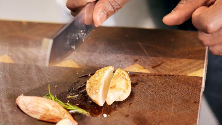 Main avec couteau de cuisine au-dessus des ingrédients.