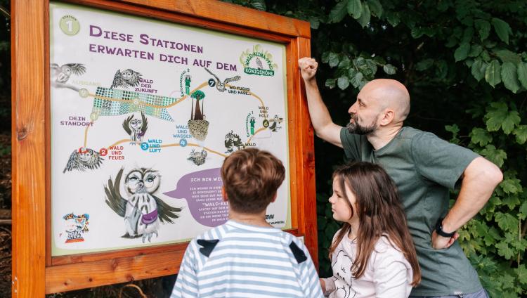 Eine Familie bei einem KiddyTrip-Abenteuer im Wald