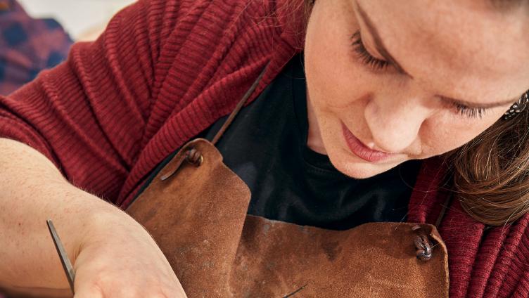 Judith Huppertz looks down, work on a violin. 