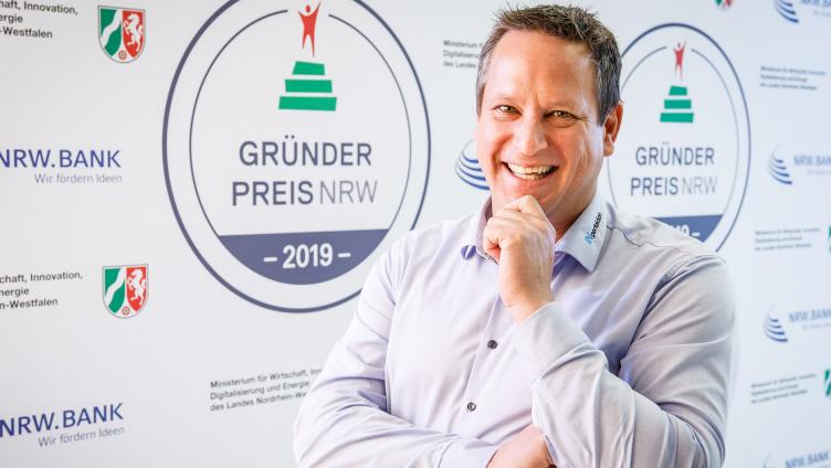Mann lacht in die Kamera.