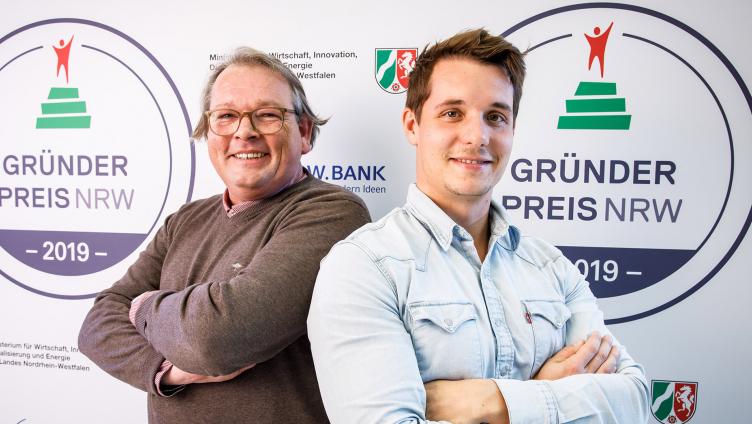 Zwei Männer lächeln in die Kamera.